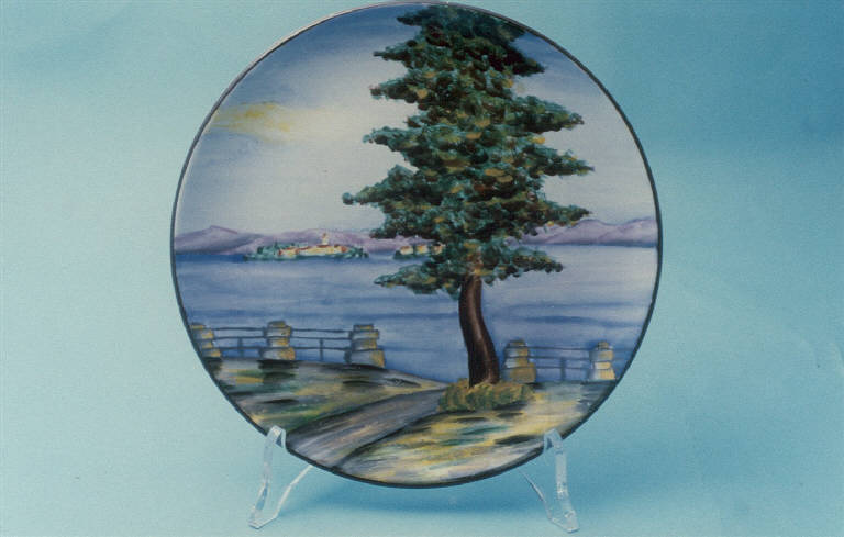 Veduta della sponda del lago con abete e parapetto (piatto da parete) di Società Ceramica Revelli (metà sec. XX)