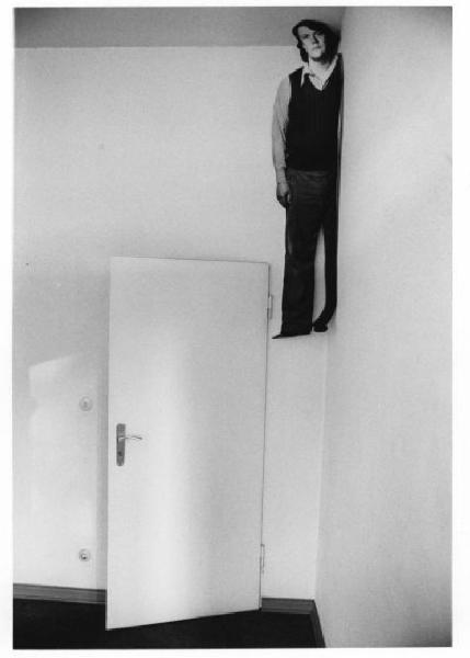 Sagoma in carta che raffigura l'autore attaccata al soffitto di una stanza vuota
