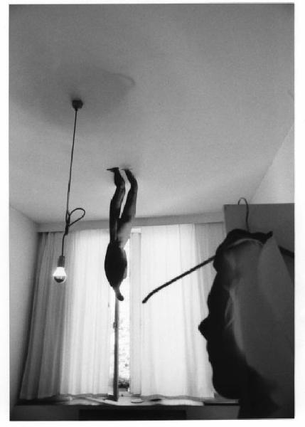 Sagoma in carta di figura femminile nuda attaccata al soffitto di una stanza