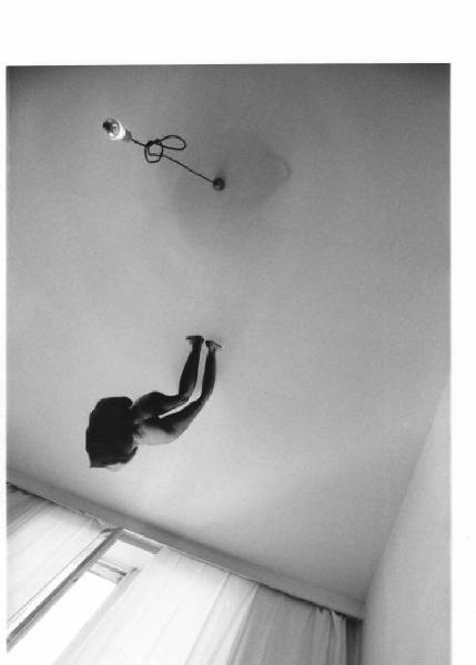 Sagoma in carta di figura femminile nuda attaccata al soffitto di una stanza