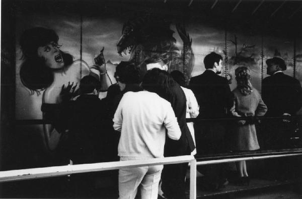 Gruppo di persone osserva dipinti aerografati