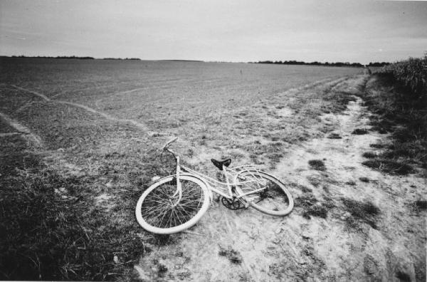 Bicicletta abbandonata ai margini di un campo