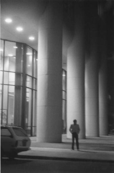 Uomo in attesa davanti alle colonne di un palazzo