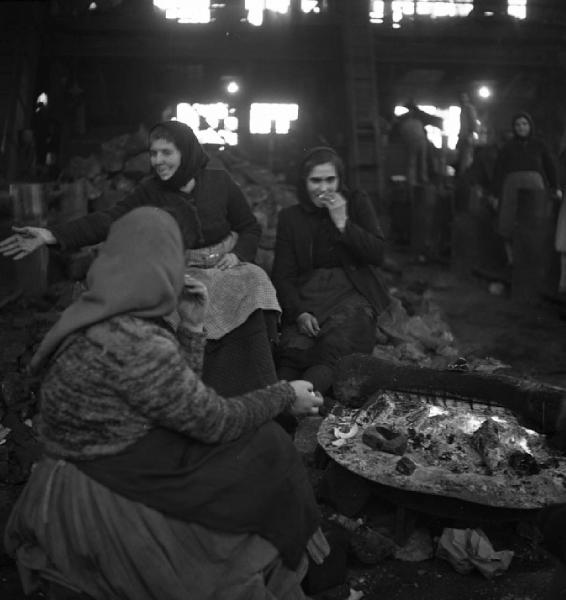 Italia del Sud. Sardegna, Carbonia - Miniera di carbone - Capannone, interno - Ritratto di gruppo: donne addette alla cernita del carbone (dette cernitrici) - Pausa pranzo