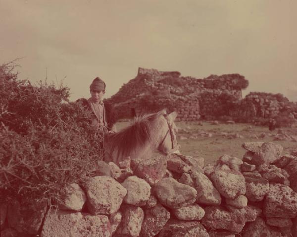 Italia del Sud. Sardegna - nuraghe Arrubiu - giovane pastore a cavallo