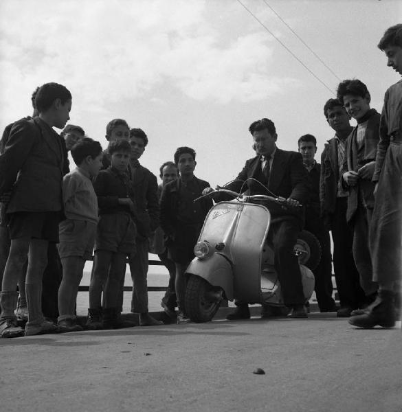 Italia del Sud. Calabria - bambini osservano un uomo con Lambretta