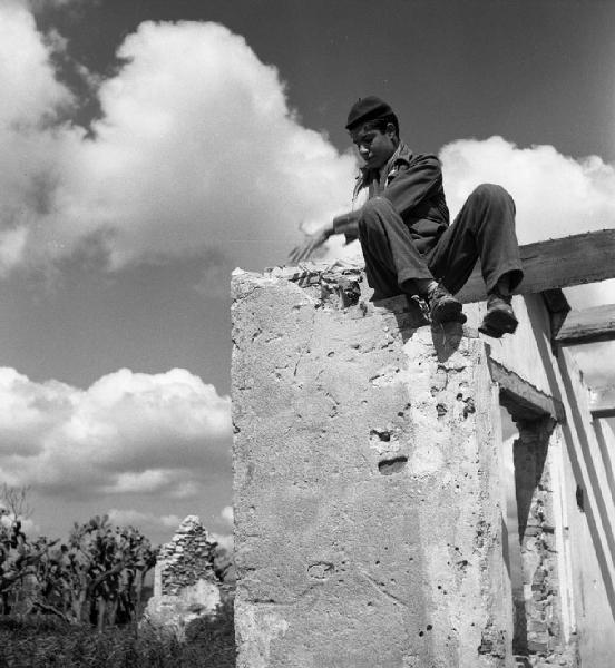Italia del Sud. Calabria - edificio semidiroccato - bambino appollaiato su un muro