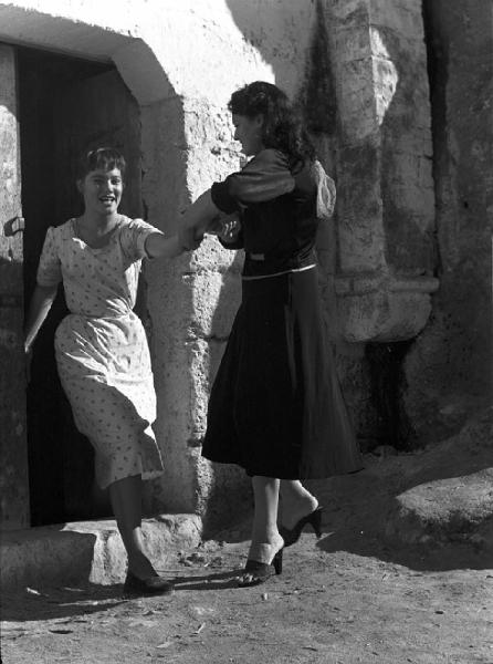 Matera. Le attrici Kerima e May Britt davanti ad una casa sul set del film "La lupa" di Alberto Lattuada