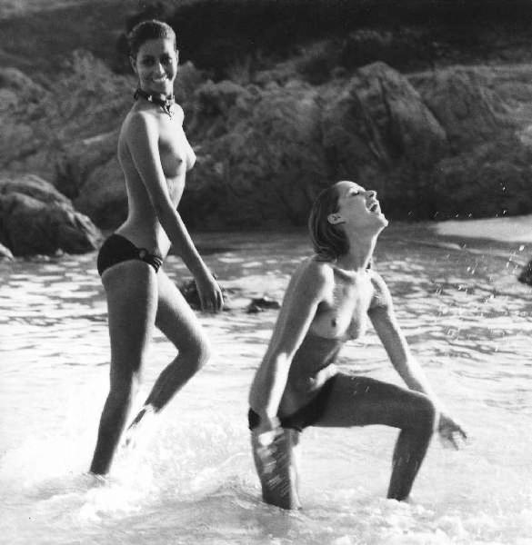 Due donne a seno scoperto giocano in mare