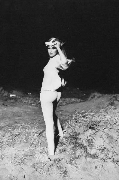Ostia - Set del film "La decima vittima" di Elio Petri - Spiaggia - Ritratto femminile a figura intera con occhiali da sole: Ursula Andress, modella