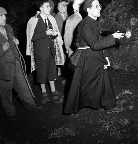 Italia del Sud. Sicilia - eruzione dell'Etna - processione lungo le pendici del vulcano - prete con la torcia