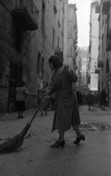 Italia del Sud. Napoli - donna spazza un vicolo