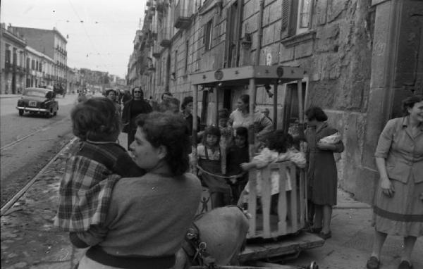 Italia del Sud. Napoli - giostra di fortuna trainata da un asinello - mamme e bambini