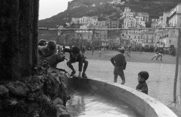 Italia del Sud. Positano - fontana - ragazzini assistono a una partita di pallone