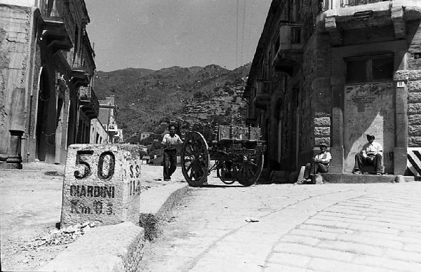 Italia del Sud. Taormina - pietra miliare con indicazione "Giardini" Km 0.5 - carretto siciliano