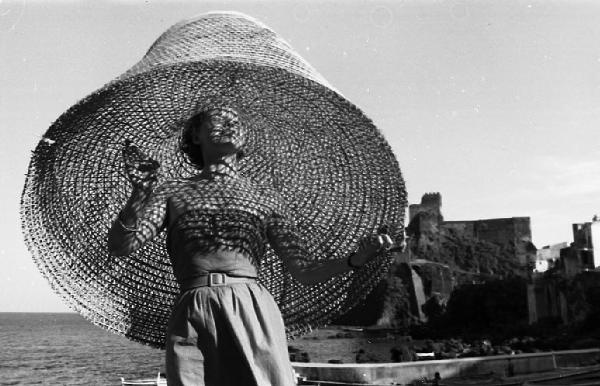 Italia del Sud. Aci Castello - ritratto femminile - donna con nassa in testa