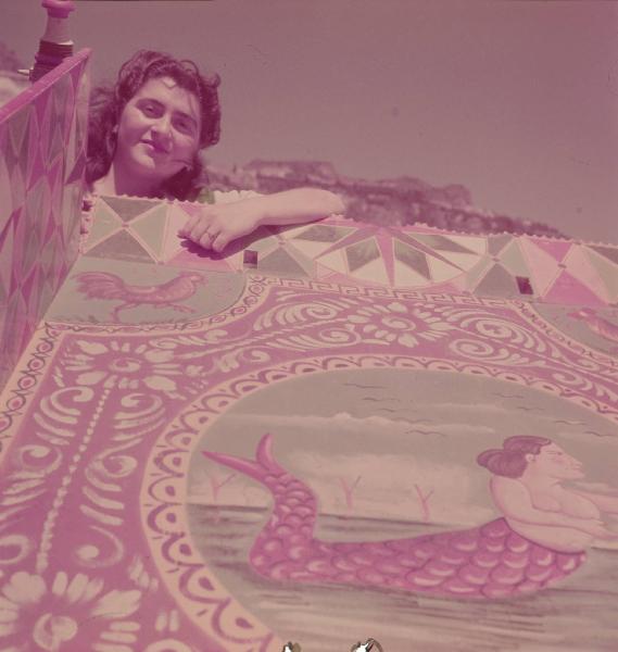 Italia del Sud. Taormina - ritratto femminile - donna appoggiata al pianale (fonnu di càscia) decorato di un carretto siciliano