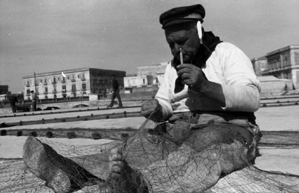 Italia del Sud. Siracusa - ritratto maschile - pescatore - manutenzione delle reti da pesca