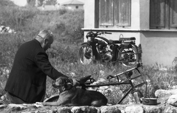 Italia del Sud. Terni - uomo con bicicletta - cane accovacciato su un muretto