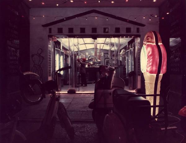 Parma. Veduta notturna di una gelateria con motorini parcheggiati in primo piano