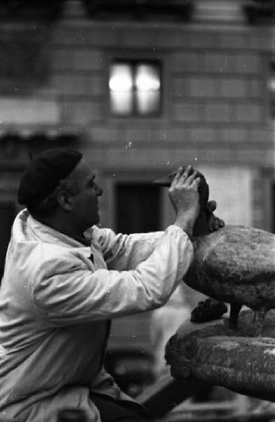 Italia del Sud. Palermo - uomo accarezza una scultura della Fontana Pretoria