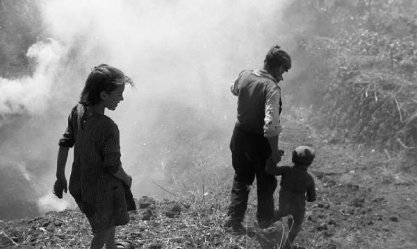 Italia del Sud. Sicilia - pendici dell'Etna - un adulto e due bambini presso una fumarola