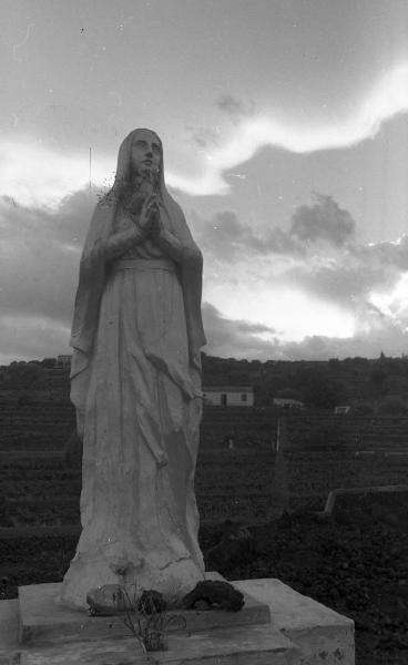 Italia del Sud. Sicilia - paese etneo - statua della Madonna a ridosso del fronte lavico