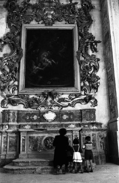 Italia del Sud. Catania - interno di una chiesa - madre e figlia davanti a un altare laterale