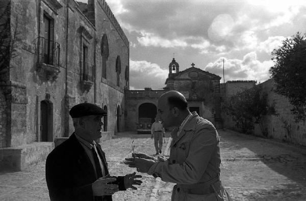 Italia del Sud. Sicilia - borgo fortificato - piazza della chiesa - uomini in conversazione