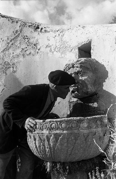 Italia del Sud. Sicilia - uomo si abbevera alla fontana