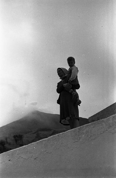 Italia del Sud. Sicilia - Isole Eolie - isola di Stromboli - San Vincenzo - donna con bambino in spalla