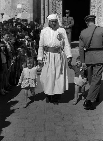 Italia del Sud. Matera - processione dei Santi Medici Cosma e Damiano - ritratto maschile - associato di una confraternita - confratello con bambini per mano