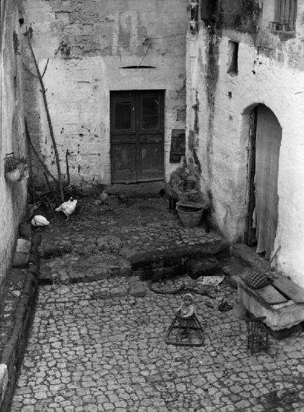 Italia del Sud. Matera - centro storico - corte interna - ritratto famminile - bambina nel girello