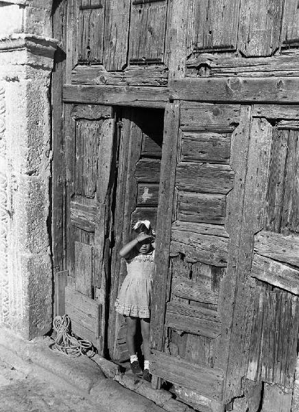 Italia del Sud. Matera - portone di legno - bambina sulla soglia