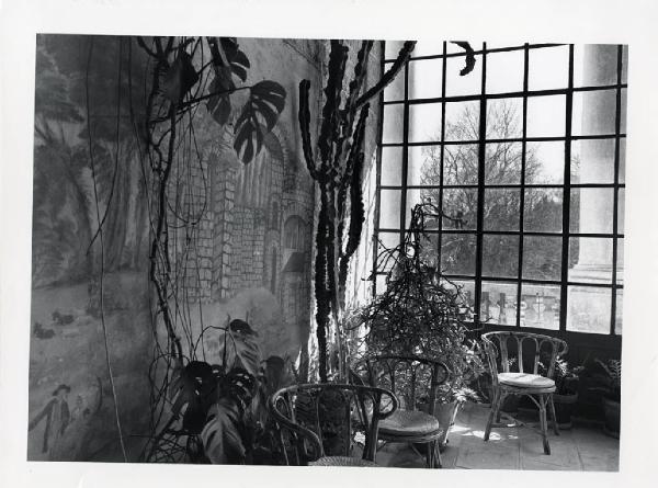 Monopoli. Giardino Meo Evoli - sedie in vimini - piante grasse - finestra con grata - affresco con castello