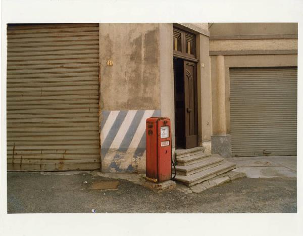 Santo Stefano Belbo. Pompa rossa per il gasolio - saracinesche di garage - porta