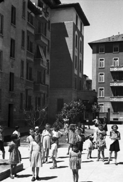 Italia Dopoguerra. Periferia di Milano, le case popolari del quartiere "Baia del Re". Condomini nel cortile interno. Numerosi bambini,