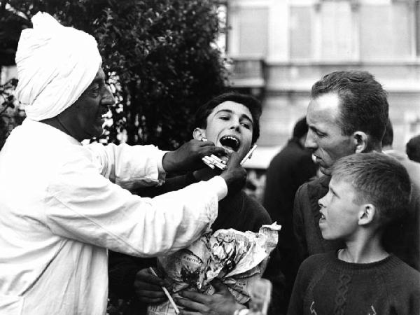 Fiera di Sinigaglia. Milano - Mercatino - Ritratto di gruppo - Guaritore indiano in abito tradizionale e bambini - Dimostrazione in pubblico - Bocca, denti