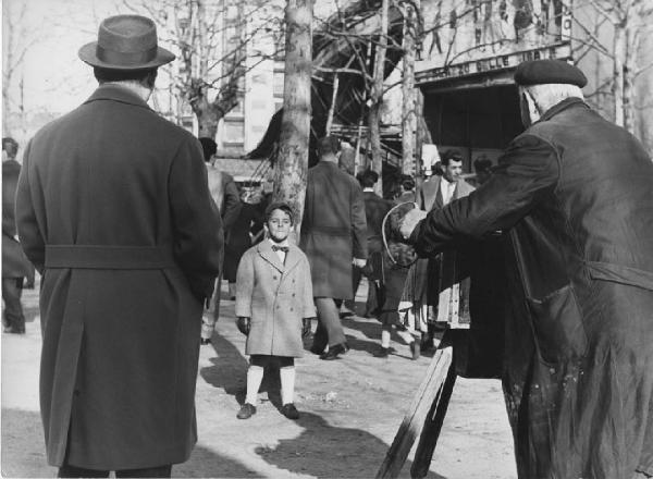 Luna park. Milano - Luna park - Ritratto di gruppo - Fotografo ambulante con bambino in posa davanti alla macchina fotografica a soffietto - Uomo di spalle