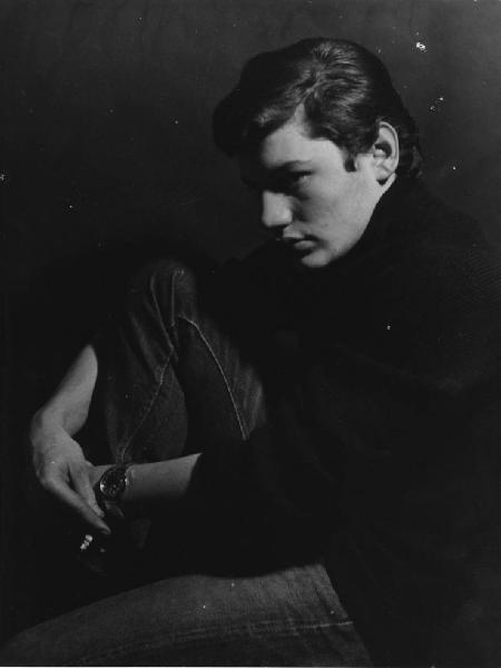 Giovani. Ritratto maschile - Ragazzo seduto con gamba piegata e sigaretta in mano - Fumo