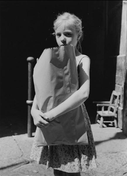 Napoli: Scugnizzi, si lavora. Napoli - Vicoli - Ritratto infantile - Bambina con sacchetto di carta in mano - Pane