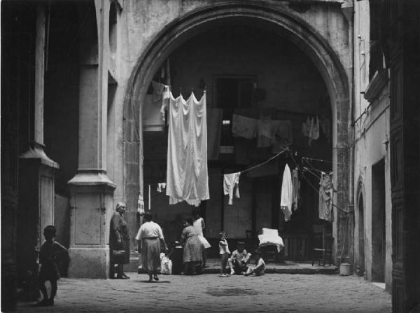 Napoli: Vicoli. Napoli - Vicoli - Cortile di una casa - Arco - Panni stesi - Bambini e Donne