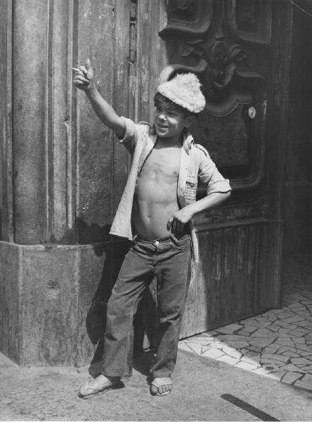 Napoli: Scugnizzi, guappetti. Napoli - Vicoli - Ritratto infantile - Bambino con camicia aperta, cappello di pelo, sigaretta in mano e pollice alzato