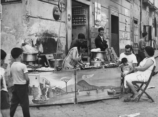 Napoli: Si vende si compra. Napoli - Vicoli - Banchetto street food con pesce: polipi - Bambini