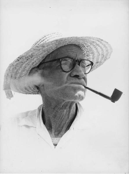 Napoli: Volti figure, uomo. Napoli - Ritratto maschile - Anziano con pipa in bocca, occhiali e cappello di paglia - Fumo