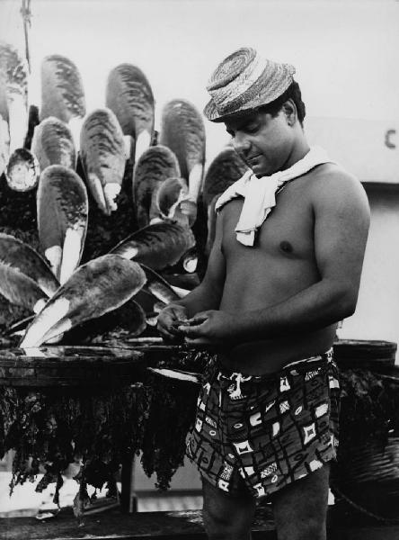 Napoli: Mare. Napoli - Mare - Ritratto maschile - Uomo in costume e cappello di paglia pulisce molluschi - Pesce, alghe, cozze