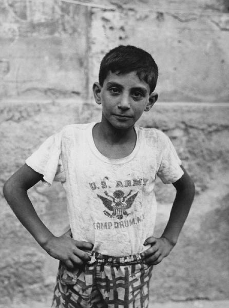 Napoli: Bimbi, soli. Napoli - Esterno - Ritratto infantile - Bambino con mani alla vita, maglietta U.S. Army