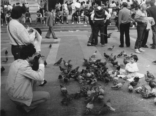 Piazza Duomo: La foto. Milano - Piazza del Duomo - Ritratto di famiglia - Adulto con macchina fotografica - Bambina seduta - Piccioni