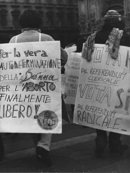 Piazza Duomo: Scritti. Milano - Piazza del Duomo - Manifestazione - Uomini con cartelli con scritte politiche: pro aborto, referendum