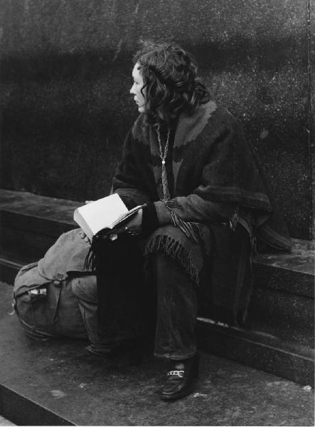 Mondo Beat. Milano - Piazza del Duomo - Monumento a Vittorio Emanuele II - Ritratto femminile - Ragazza seduta con poncho e libro - Lettura